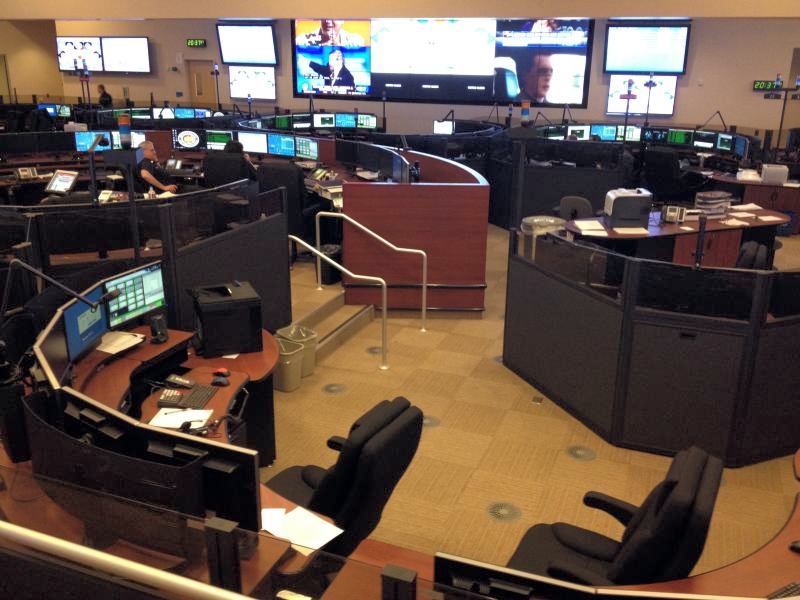 LAFD's Dispatch center. Multiple desks in a rounded configuration with multiple monitors.