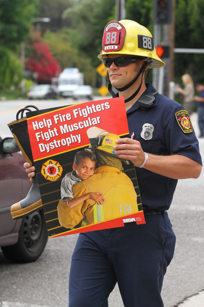 Firefighter with sign raising money for MDA Fill the Boot