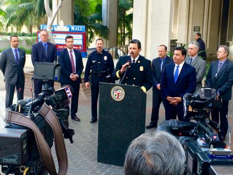 Fire Chief Terrazas speaking at a lectern to the news media.