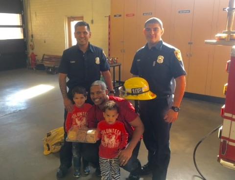 Firefighters and a family at fire station 102.