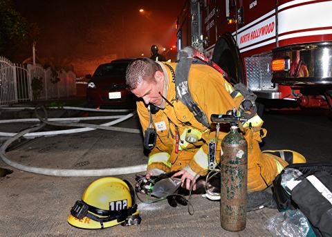 Firefighter using oxygen mask on cat rescued from fire