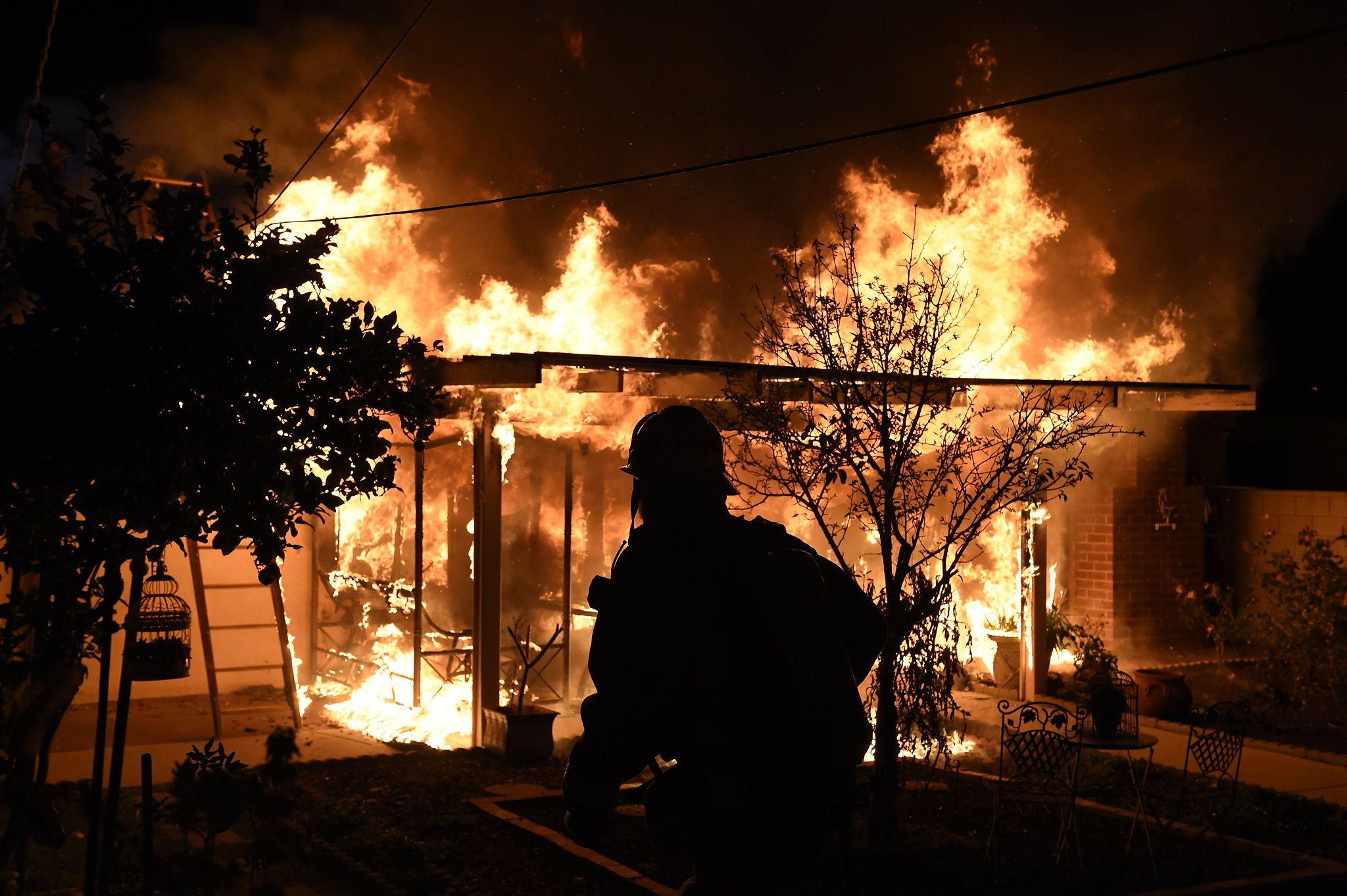 Burning house with a Firefighter in the foreground.  
