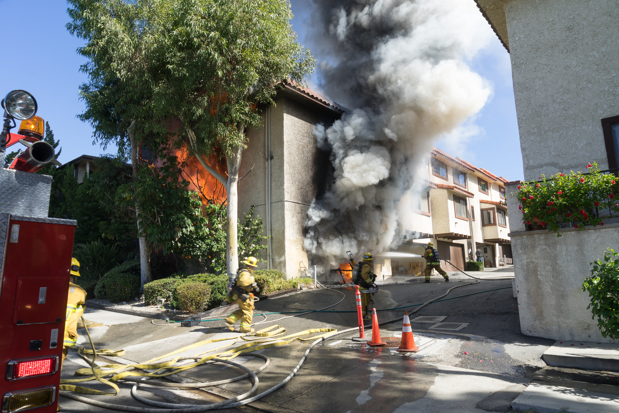 Exterior view of 2 story townhouse with fire showing