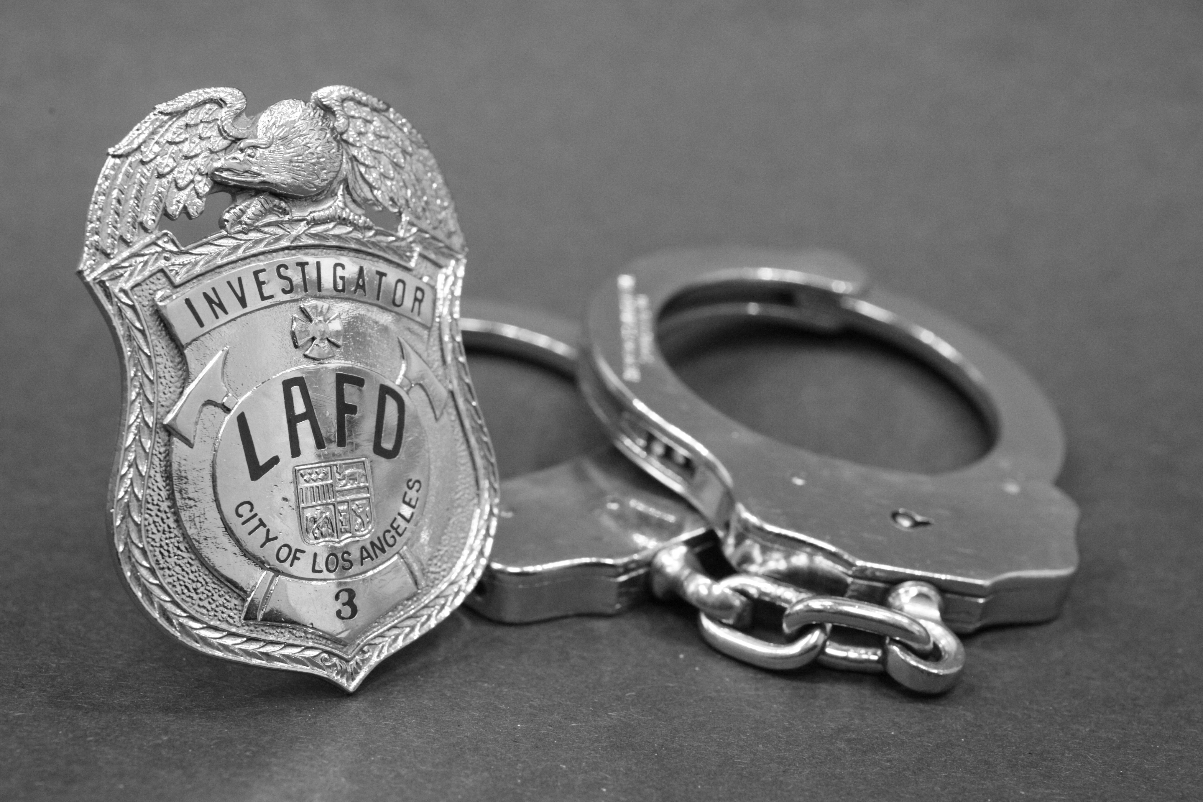 Stock Image: LAFD Investigator badge and pair of handcuffs