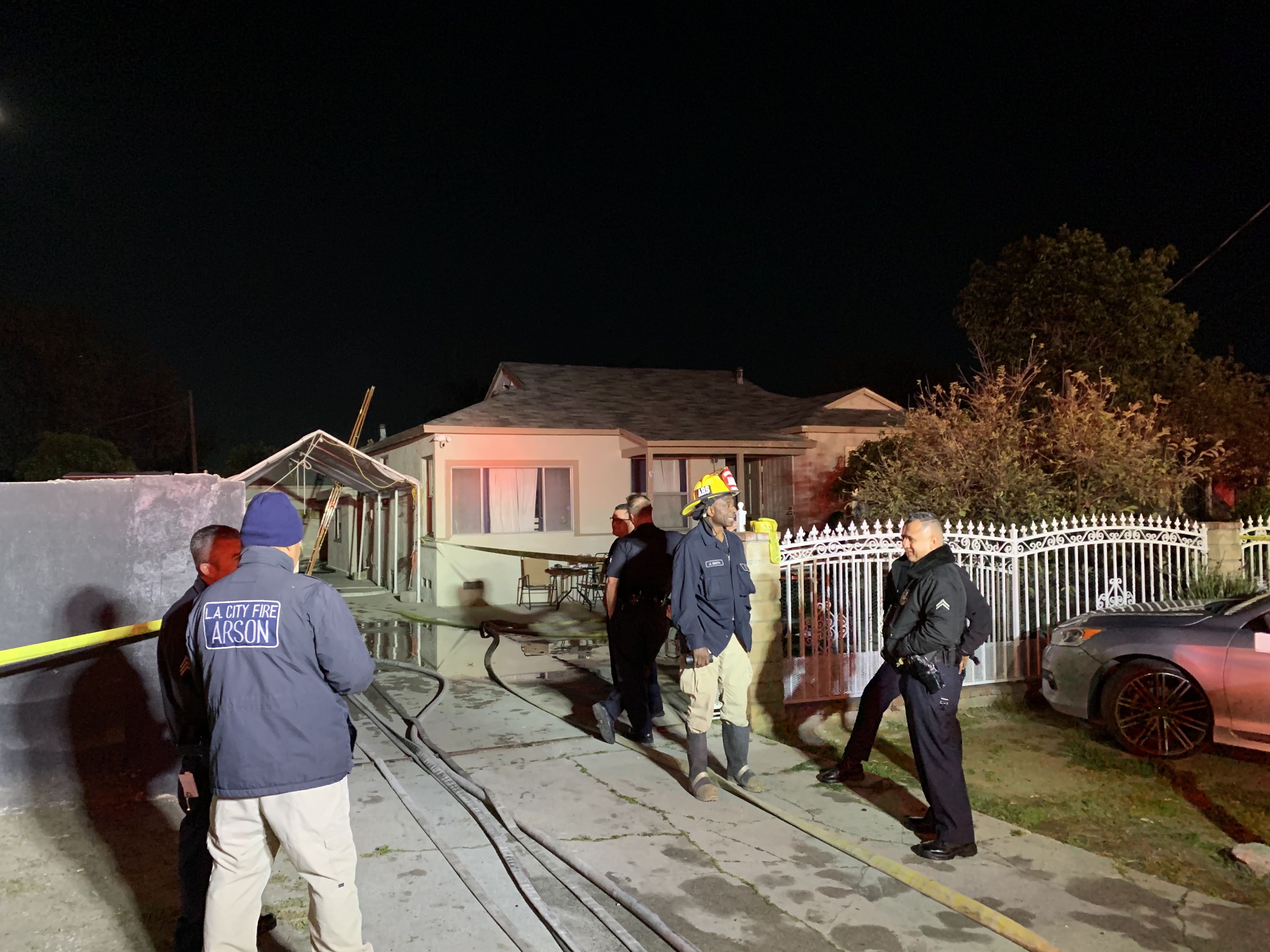 Fire Investigators and Police standing in front of a property that was the location of a fatal structure fire