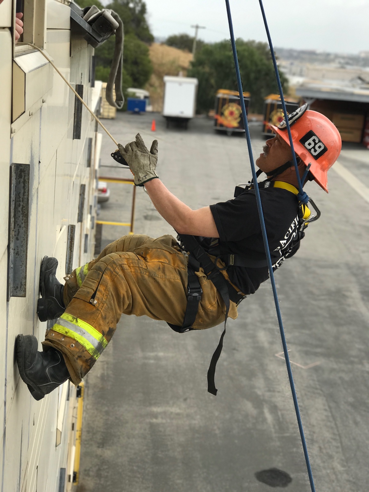 Subject rappelling on side of building