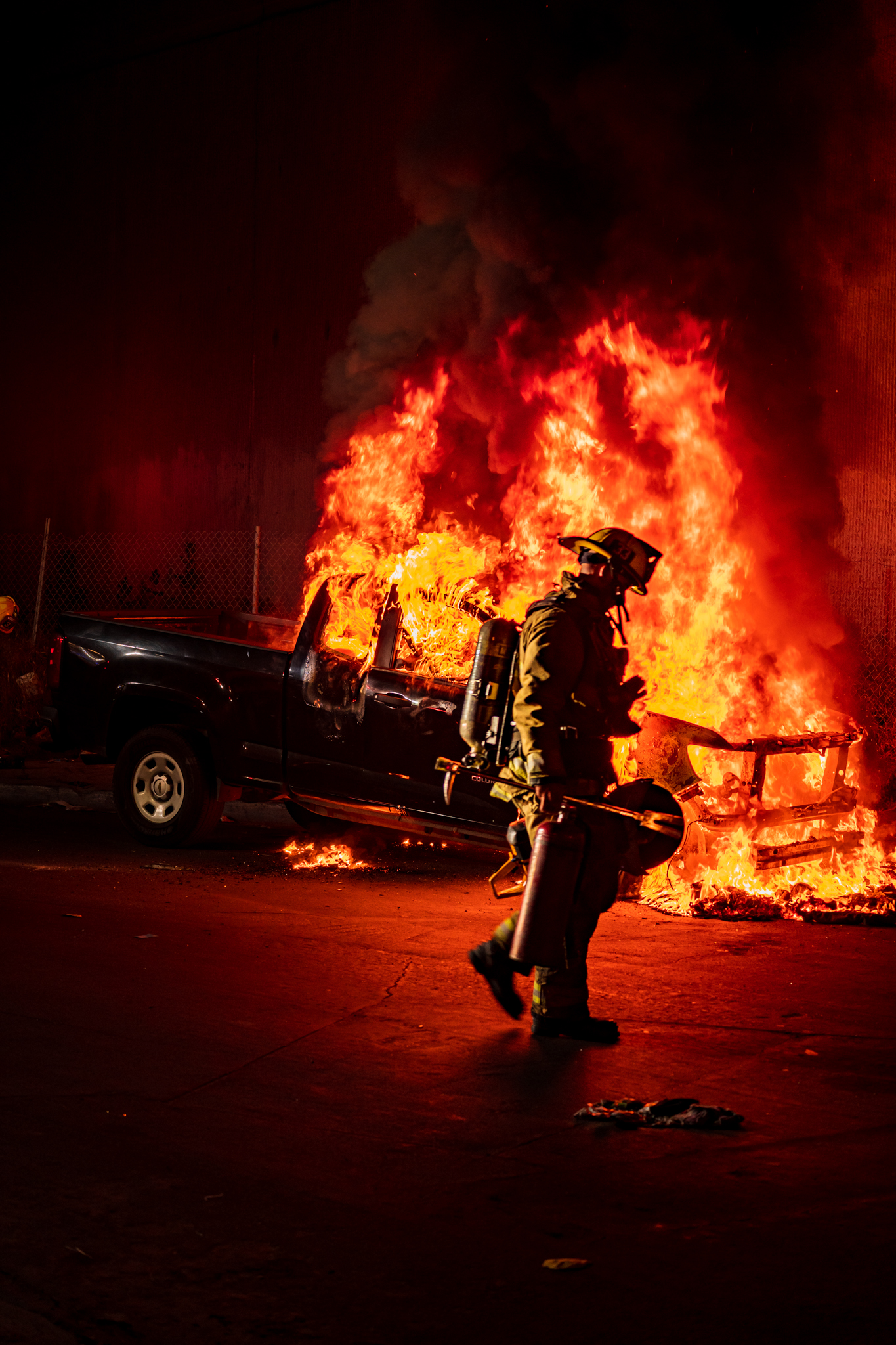 Firefighter walking in front of an auto fire