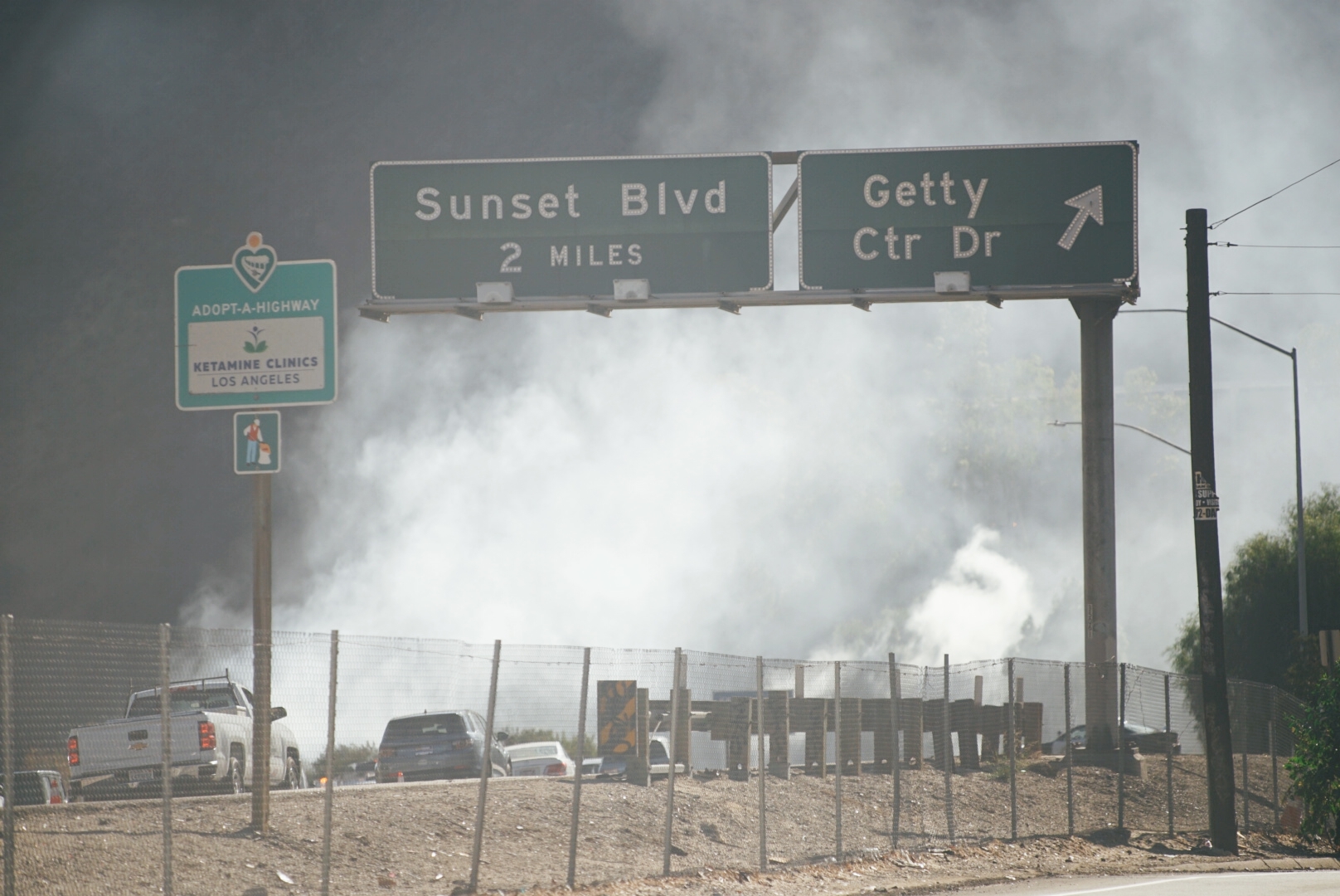 Freeway signs obscured by brush fire smoke