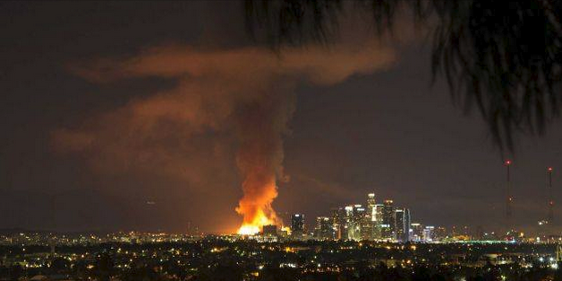 Distant view of Los Angeles skyline with a huge fire and smoke column.